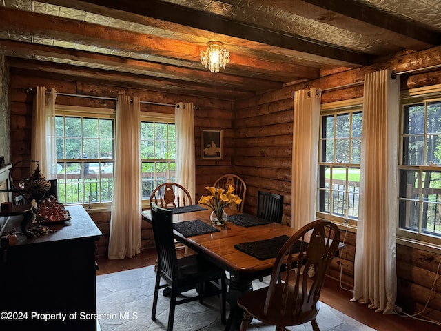 dining room featuring log walls, beam ceiling, a notable chandelier, and hardwood / wood-style floors