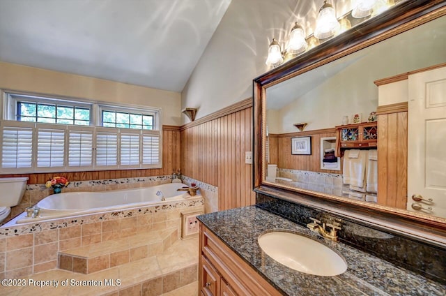 bathroom with tile patterned floors, vanity, lofted ceiling, and tiled tub