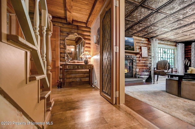 corridor with log walls and hardwood / wood-style floors