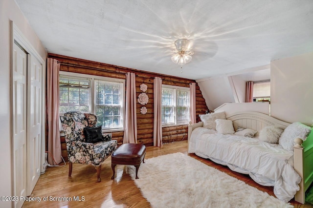 interior space featuring ceiling fan, lofted ceiling, log walls, and a closet