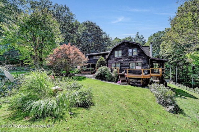 back of house featuring a yard and a wooden deck