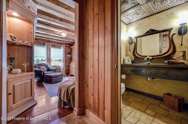 bathroom featuring log walls and toilet