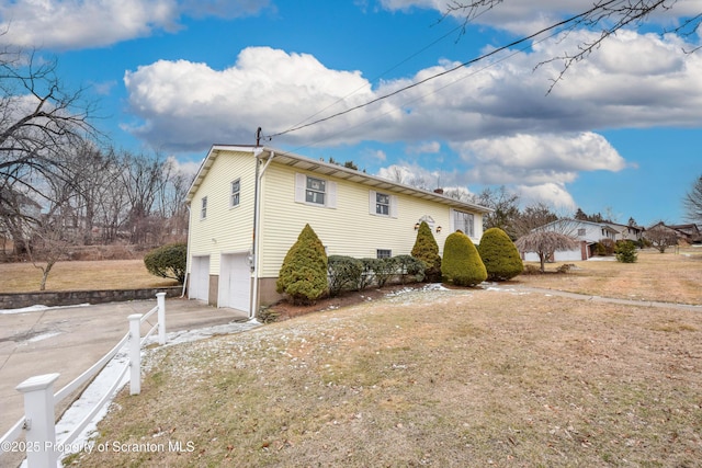 view of side of property with a garage and a lawn