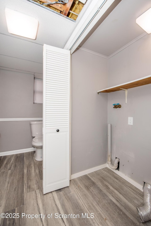 clothes washing area with crown molding and hardwood / wood-style floors