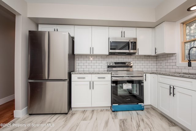 kitchen with sink, backsplash, white cabinets, and stainless steel appliances