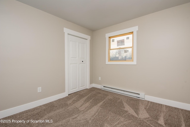 carpeted spare room featuring a baseboard heating unit