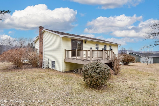 back of property featuring a yard, a wooden deck, and ac unit