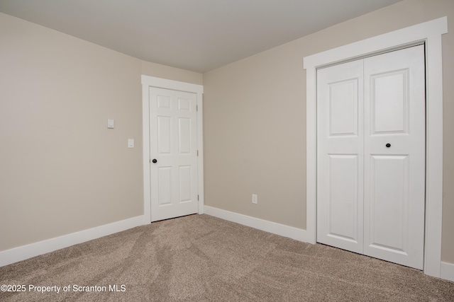 unfurnished bedroom featuring carpet floors and a closet