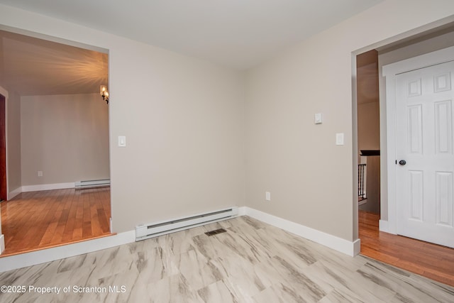 empty room with light hardwood / wood-style flooring, a chandelier, and a baseboard radiator