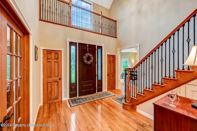 entryway with a high ceiling and wood-type flooring