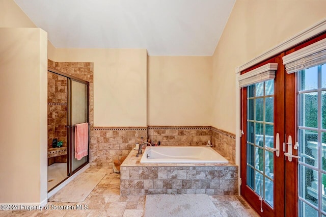 bathroom featuring french doors, independent shower and bath, and lofted ceiling