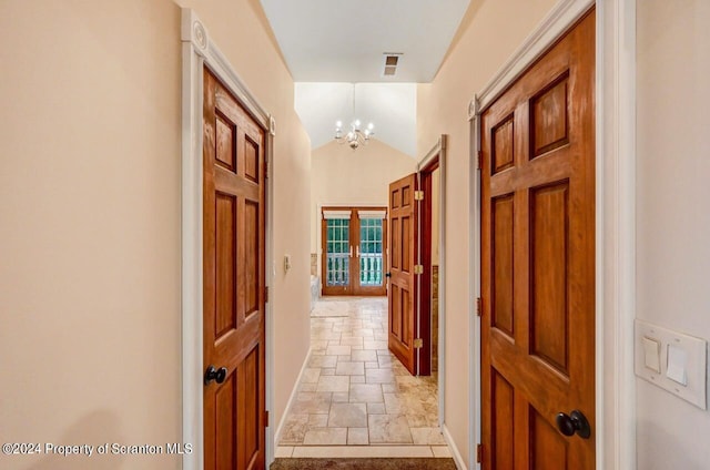 hall with a chandelier and vaulted ceiling