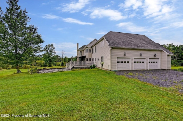 view of side of home with a yard, a garage, and a wooden deck