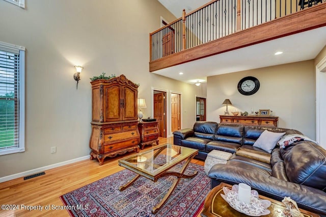 living room featuring a high ceiling and light hardwood / wood-style floors