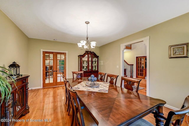 dining room with french doors, a notable chandelier, and light hardwood / wood-style flooring