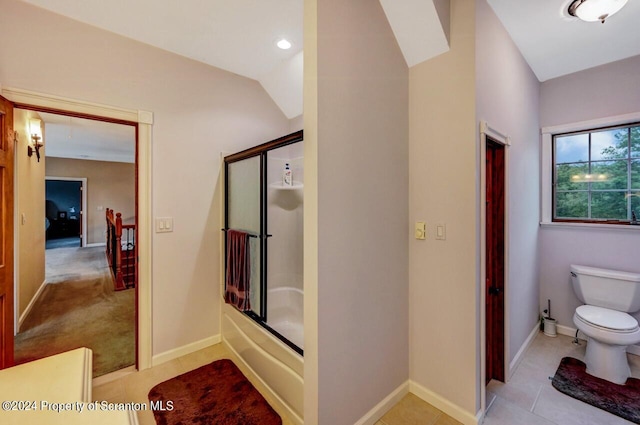 bathroom with tile patterned flooring, toilet, lofted ceiling, and bath / shower combo with glass door