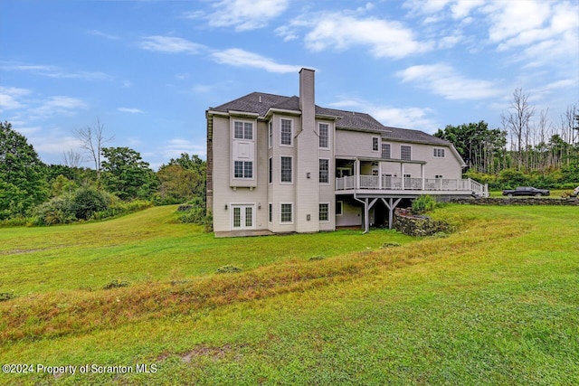 rear view of house with a lawn and a wooden deck