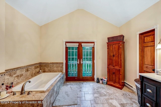 bathroom with french doors, a baseboard radiator, tiled tub, lofted ceiling, and vanity