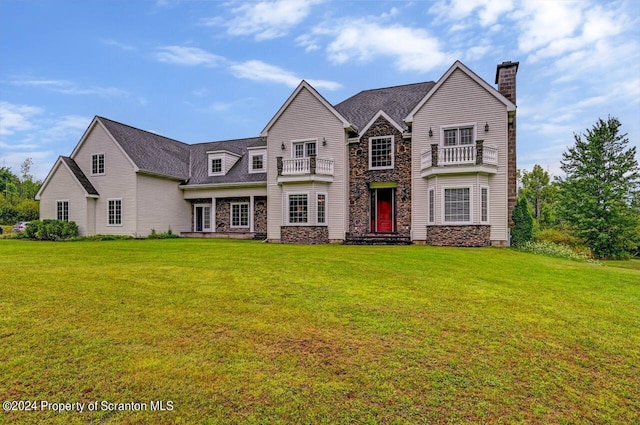 view of front facade featuring a balcony and a front lawn