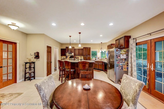 tiled dining room featuring french doors and sink