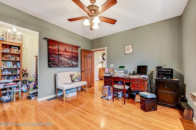 office area featuring light hardwood / wood-style floors and ceiling fan with notable chandelier