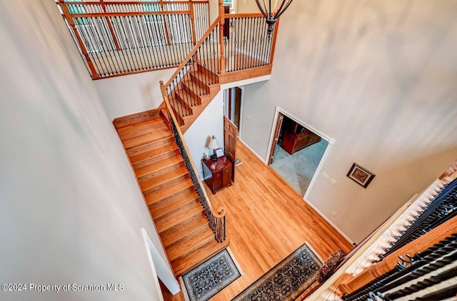 stairs featuring wood-type flooring and a towering ceiling