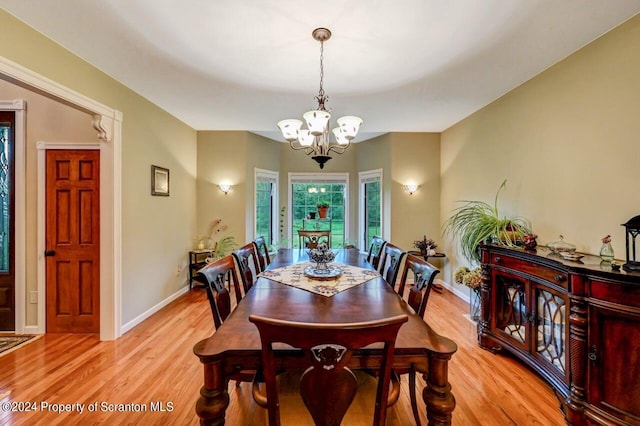 dining area with a chandelier and light hardwood / wood-style flooring