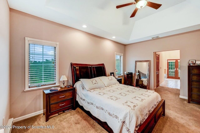 carpeted bedroom with a raised ceiling, ceiling fan, and a baseboard heating unit