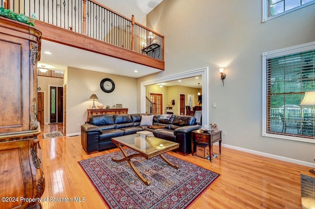 living room featuring a towering ceiling and light hardwood / wood-style floors