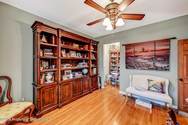 sitting room with ceiling fan and light hardwood / wood-style flooring