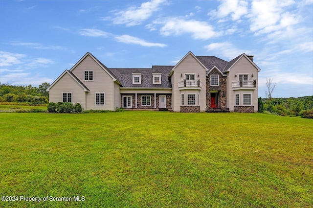 view of front of home featuring a balcony and a front lawn