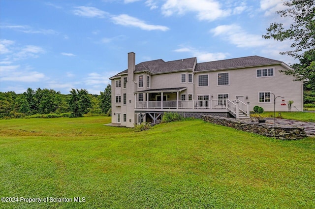 rear view of property with a wooden deck and a yard