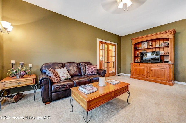 living room featuring ceiling fan, french doors, and light colored carpet