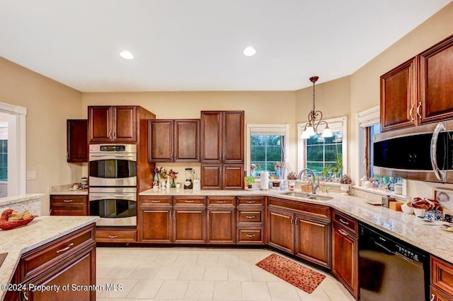 kitchen featuring light stone countertops, stainless steel appliances, sink, decorative light fixtures, and a notable chandelier