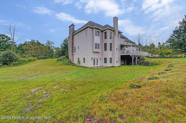 rear view of property with a yard and a deck