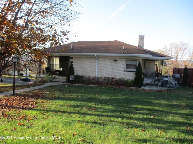 back of property featuring a lawn and a patio