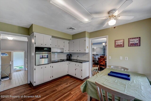 21 Leslie Dr, Scranton, PA 18505 - kitchen featuring stainless steel oven, ceiling fan, dark wood-style flooring, backsplash, and white cabinets