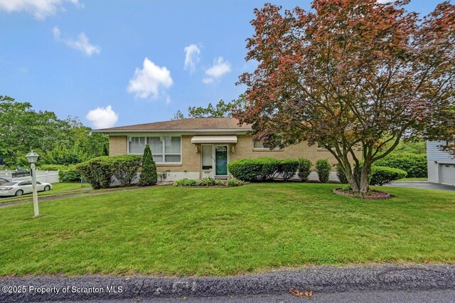 21 Leslie Dr, Scranton, PA 18505 - view of front of home featuring brick siding, a front lawn, and a garage
