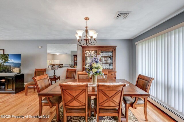 21 Leslie Dr, Scranton, PA 18505 - dining room with baseboard heating, light wood-style floors, and a chandelier
