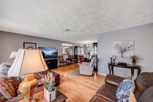 21 Leslie Dr, Scranton, PA 18505 - living room featuring a chandelier, wood finished floors, and baseboards