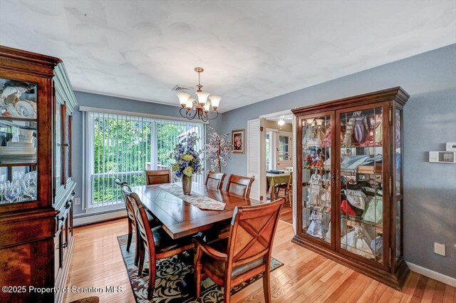 21 Leslie Dr, Scranton, PA 18505 - dining area with a chandelier, baseboard heating, light wood-style flooring, and baseboards