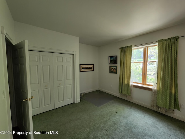 unfurnished bedroom with light colored carpet and a closet