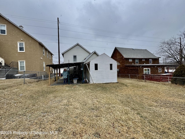 back of property featuring a fenced backyard, a lawn, and an outbuilding