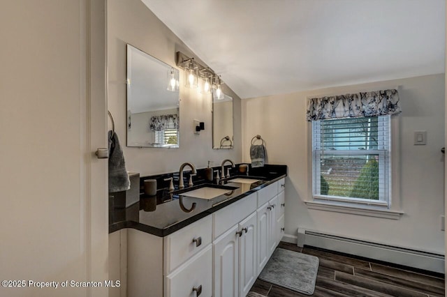 bathroom featuring baseboard heating and vanity