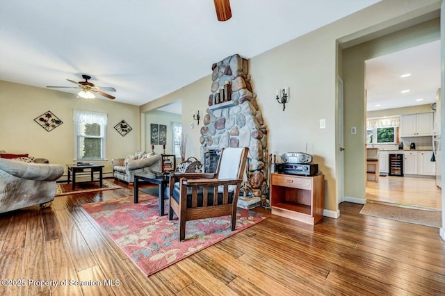 living room featuring beverage cooler, ceiling fan, and light hardwood / wood-style flooring