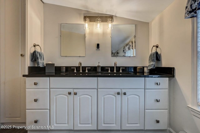 bathroom with vaulted ceiling and vanity