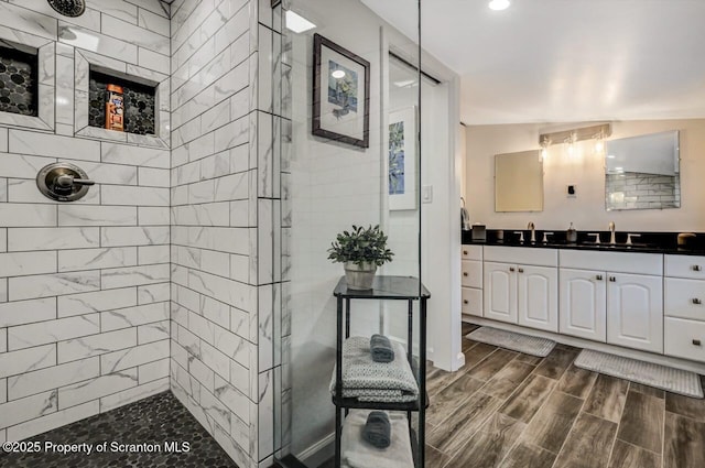 bathroom featuring a tile shower, vanity, and lofted ceiling