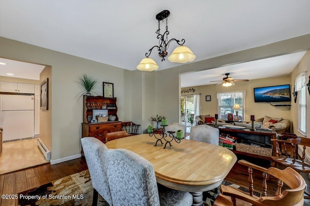 dining area featuring wood-type flooring, a baseboard radiator, and ceiling fan