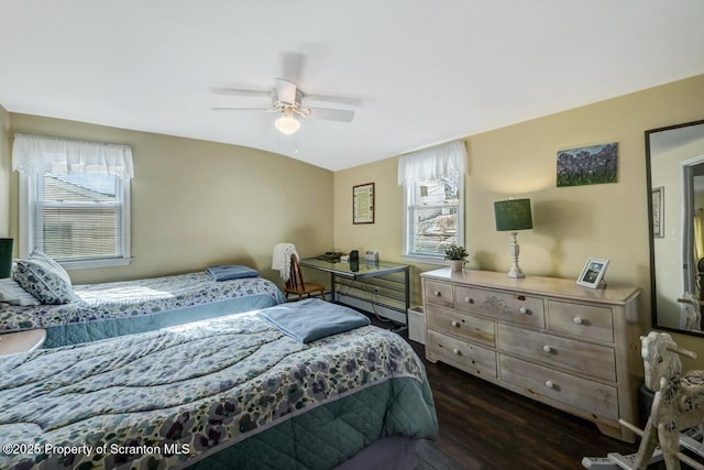 bedroom featuring vaulted ceiling, ceiling fan, dark hardwood / wood-style floors, and multiple windows