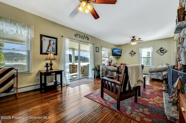 living room with ceiling fan, a wealth of natural light, and dark hardwood / wood-style floors